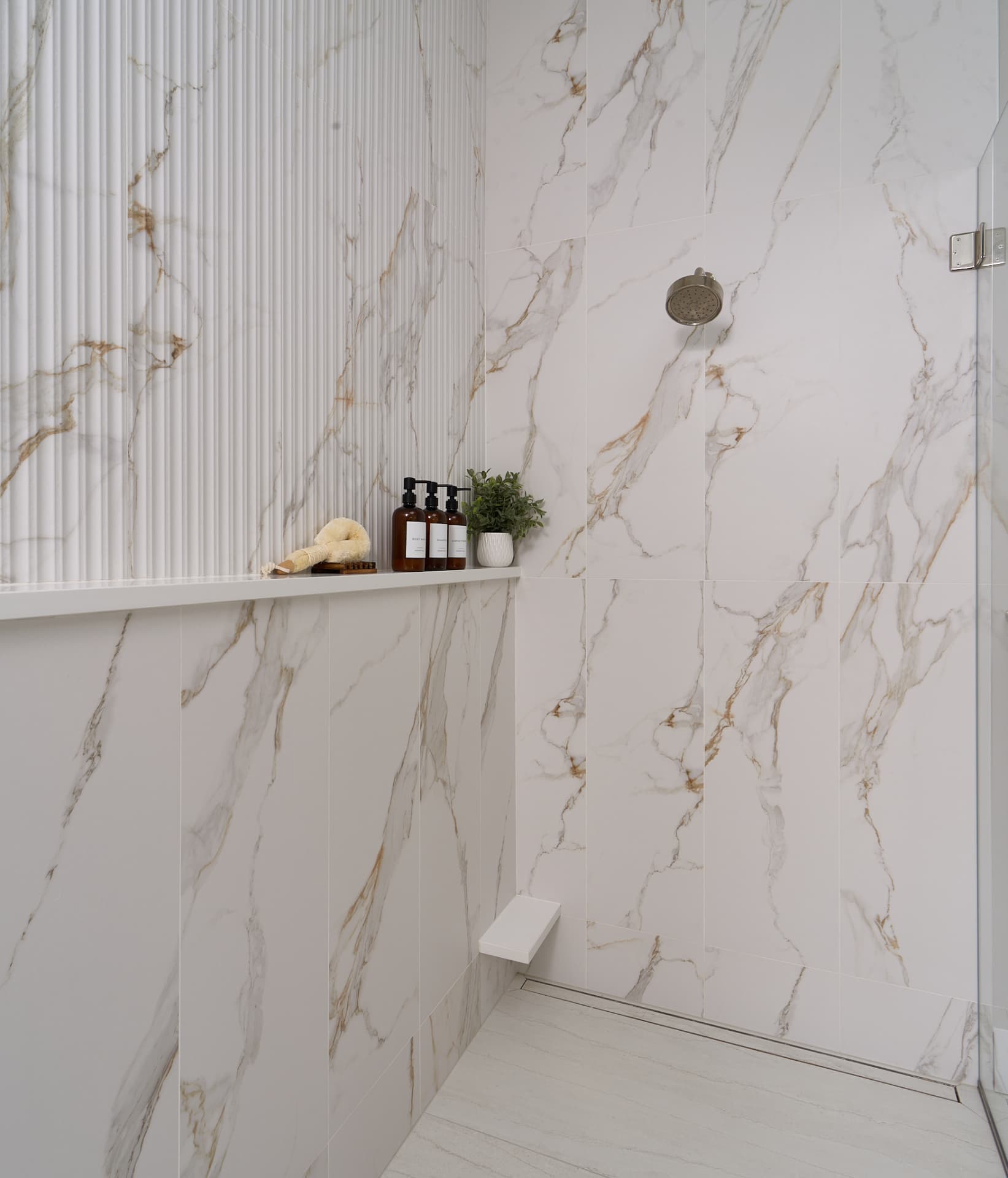 Fluted marble shower wall and continuous ledge set during a Doylestown PA bathroom remodel