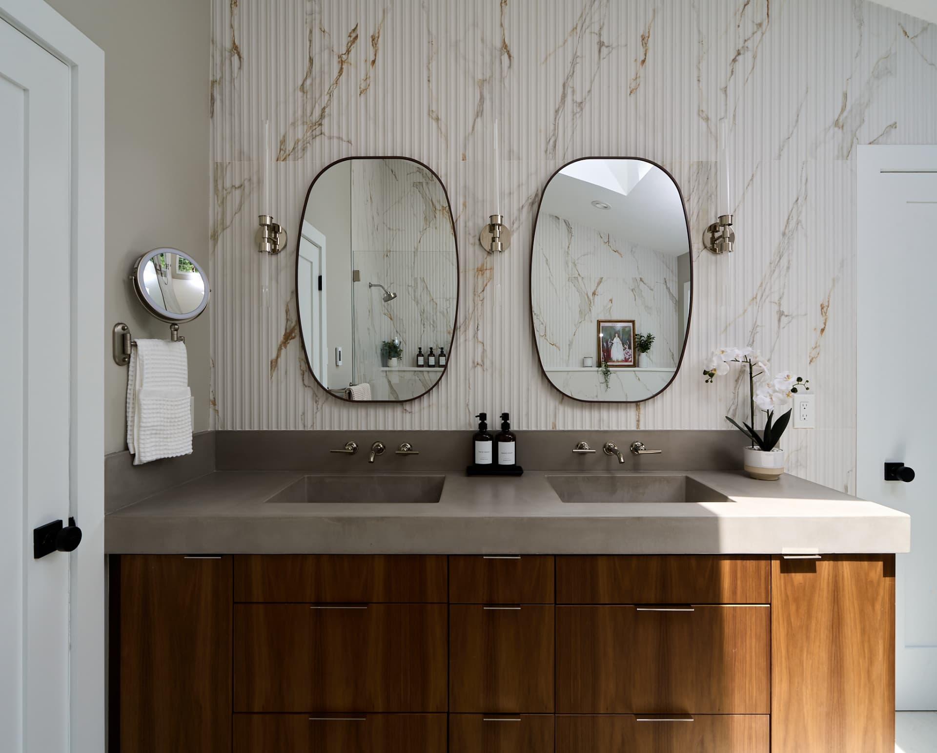 Wall mounted faucets and rounded mirrors set over a double vanity in a Bucks County PA bath remodel