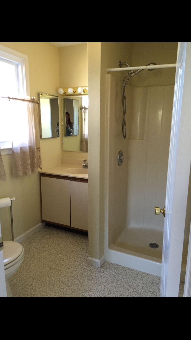 Dated hall bathroom before remodeling in Doylestown PA with a fiberglass shower stall and laminate vanity