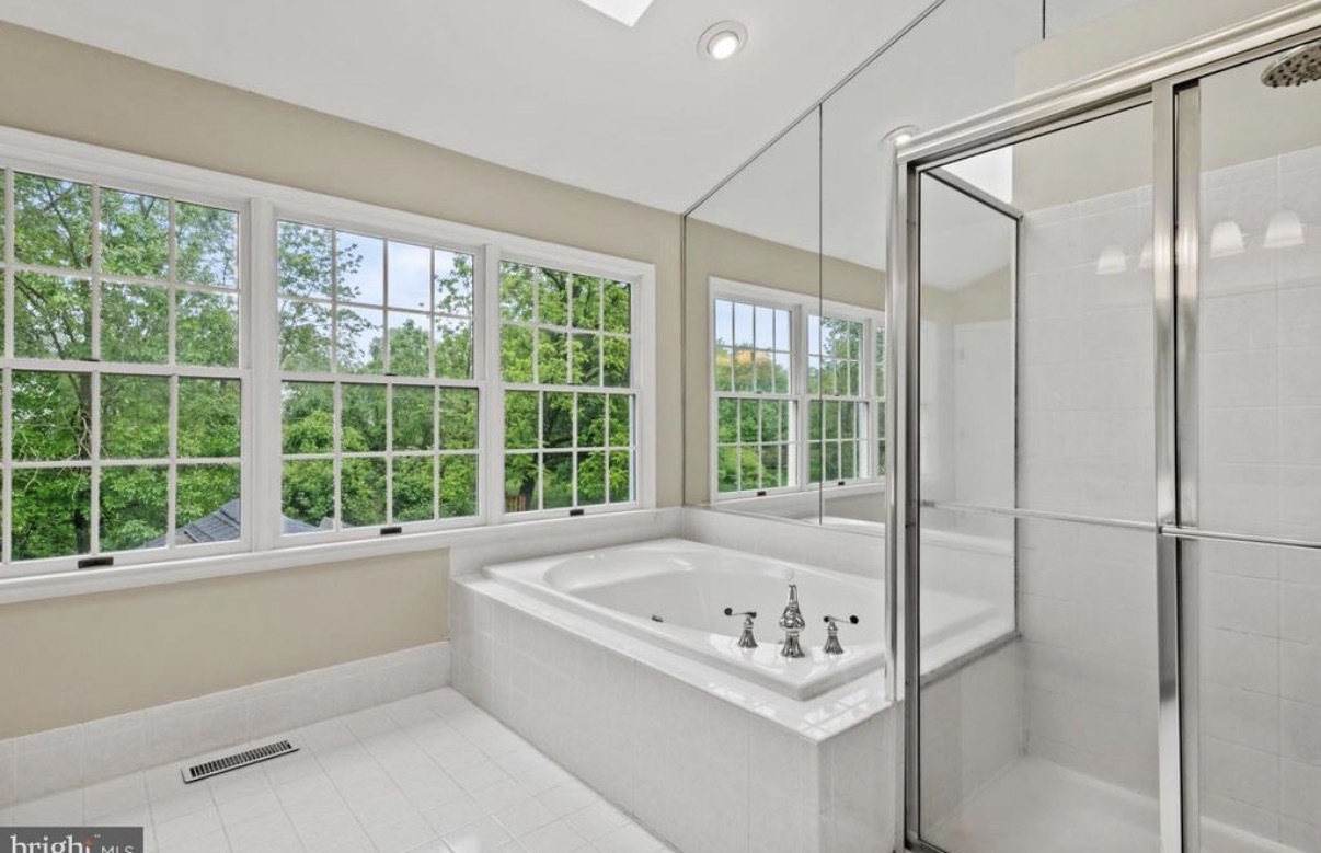 Primary bathroom before remodeling in Doylestown PA with a corner jetted tub and framed glass shower stall